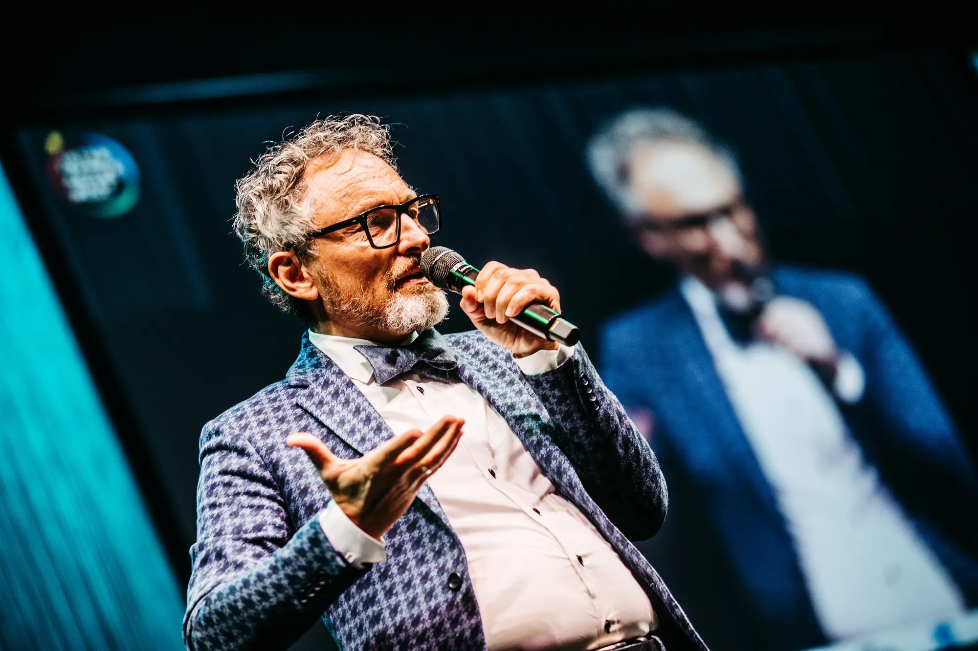 Christoph Holz delivering a keynote on stage with microphone